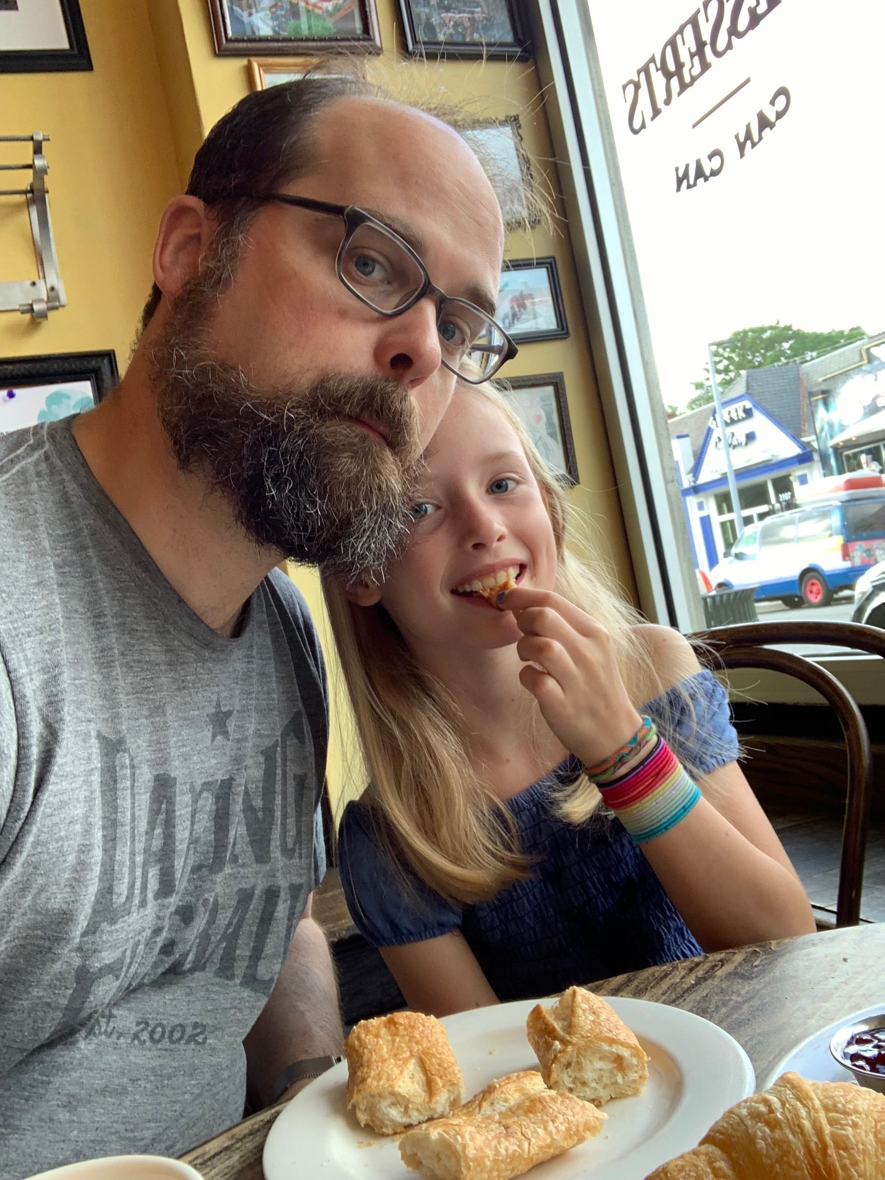 Sam and his youngest daughter take a selfie with pastries.